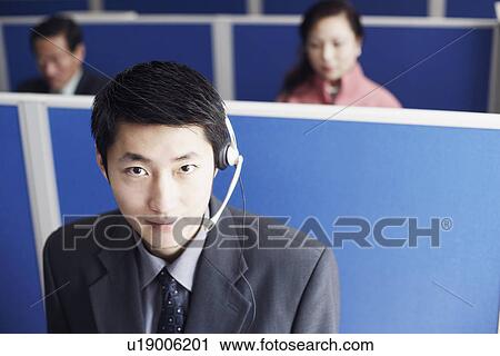 Stock Image - Portrait of a businessman wearing a headset. Fotosearch