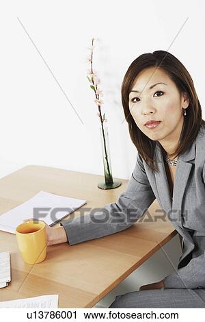 Portrait of a businesswoman holding a cup View Large Photo Image Stock Image - Portrait of a businesswoman holding a cup. Fotosearch