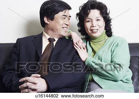 Stock Image - Portrait of a mature woman sitting with a mature man. Fotosearch