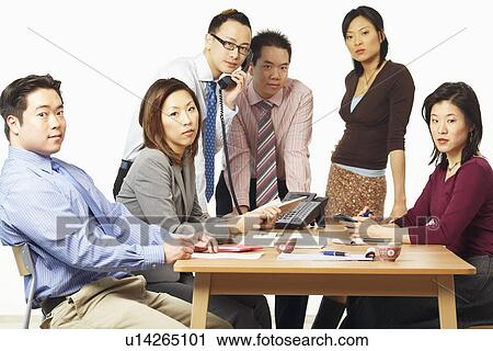 Stock Image - Portrait of three businessmen and three businesswomen in a meeting. Fotosearch