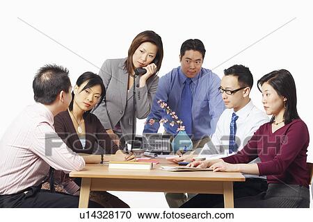 Stock Image - Three businessmen and three businesswomen in a meeting. Fotosearch