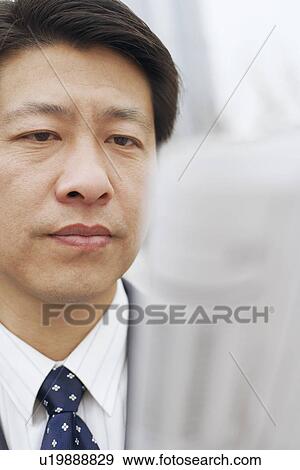 Stock Photo - Close-up of a businessman reading a newspaper. Fotosearch