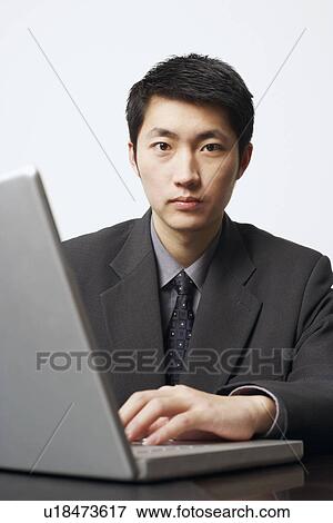 Stock Photo - Close-up of a businessman using a laptop. Fotosearch