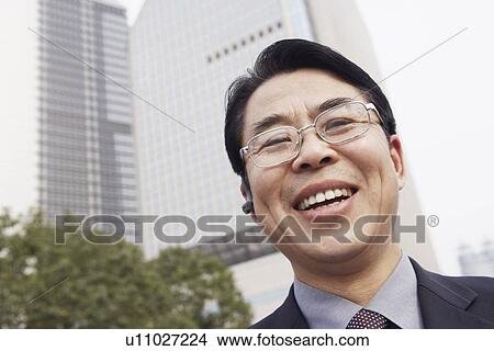 Picture - Low angle view of a businessman smiling. Fotosearch