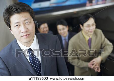 Portrait of a businessman on an escalator wearing a hands free device View Large Photo Image Stock Image - Portrait of a businessman on an escalator wearing a hands free device. Fotosearch