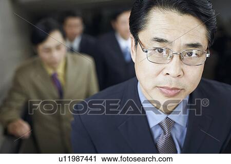 Stock Image - Portrait of a businessman on an escalator. Fotosearch