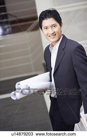 Portrait of a businessman standing on a staircase and holding blueprints View Large Photo Image Stock Image - Portrait of a businessman standing on a staircase and holding blueprints. Fotosearch