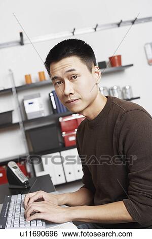 Stock Photograph - Portrait of a businessman using a computer. Fotosearch