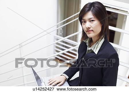 Stock Photo - Portrait of a businesswoman using a laptop. Fotosearch