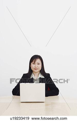 Stock Photo - Portrait of a businesswoman using a laptop. Fotosearch