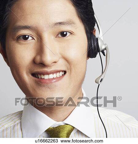 Stock Image - Portrait of a male customer service representative smiling. Fotosearch