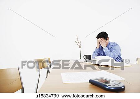 Stock Photo - Businessman sitting with his hands on his head. Fotosearch