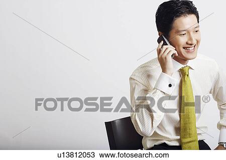 Stock Image - Close-up of a businessman talking on a mobile phone and smiling. Fotosearch