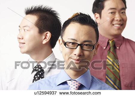 Close-up of three businessmen smiling View Large Photo Image Stock Photo - Close-up of three businessmen smiling. Fotosearch