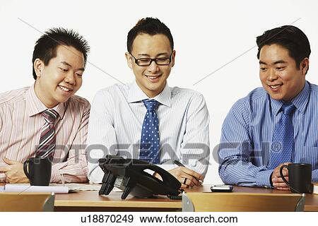 Stock Photo - Close-up of three businessmen smiling. Fotosearch