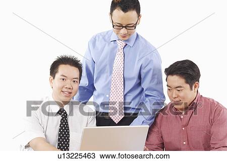 Close-up of three businessmen using a laptop View Large Photo Image Stock Image - Close-up of three businessmen using a laptop. Fotosearch