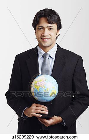 Portrait of a businessman holding a globe and smiling View Large Photo Image Stock Photo - Portrait of a businessman holding a globe and smiling. Fotosearch