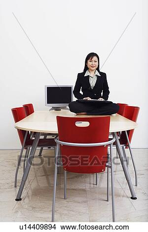 Portrait of a businessman sitting cross-legged on a table with a keyboard and smiling View Large Photo Image Picture - Portrait of a businessman sitting cross-legged on a table with a keyboard and smiling. Fotosearch