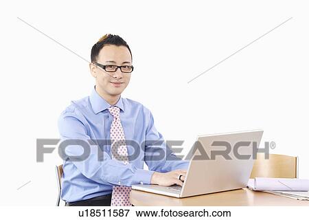 Stock Photo - Portrait of a businessman using a laptop. Fotosearch