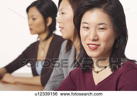 Stock Photograph - Portrait of a businesswoman sitting and smiling. Fotosearch