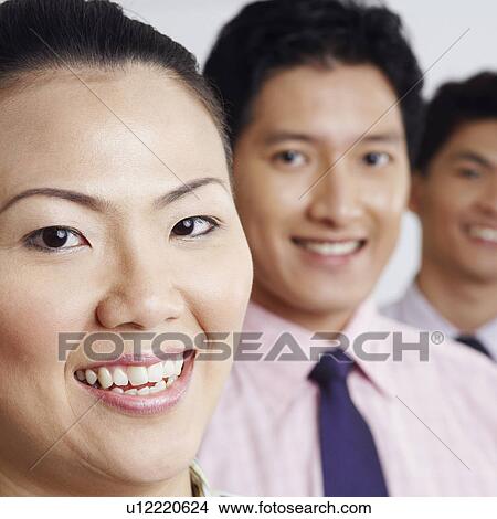 Picture - Portrait of a businesswoman smiling with two businessmen. Fotosearch