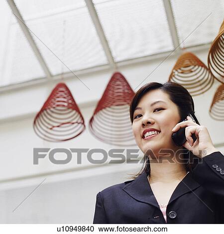Portrait of a businesswoman talking on a mobile phone and smiling View Large Photo Image Stock Image - Portrait of a businesswoman talking on a mobile phone and smiling. Fotosearch