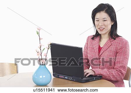 Stock Image - Portrait of a businesswoman using a laptop. Fotosearch