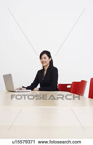Portrait of a businesswoman using a laptop and smiling View Large Photo Image Stock Image - Portrait of a businesswoman using a laptop and smiling. Fotosearch
