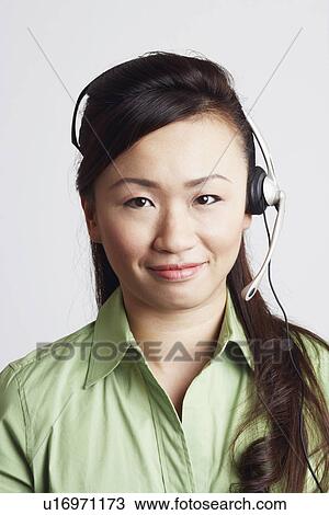 Stock Image - Portrait of a female customer service representative smiling. Fotosearch