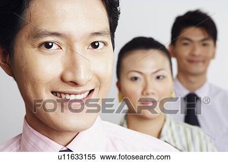 Portrait of two businessmen and a businesswoman smiling View Large Photo Image Stock Photography - Portrait of two businessmen and a businesswoman smiling. Fotosearch