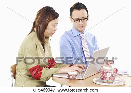 Side profile of a businesswoman and a businessman using a laptop View Large Photo Image Stock Photo - Side profile of a businesswoman and a businessman using a laptop. Fotosearch