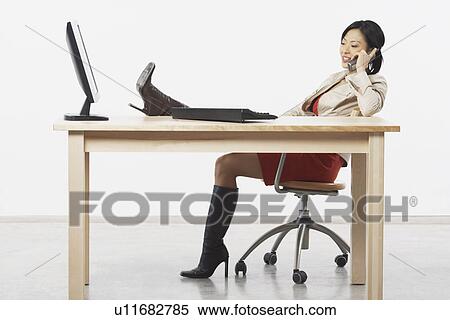 Stock Photography - Side profile of a businesswoman talking on a cordless telephone. Fotosearch