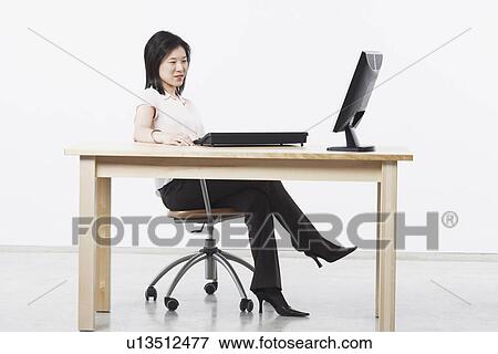 Stock Photo - Side profile of a businesswoman using a computer. Fotosearch