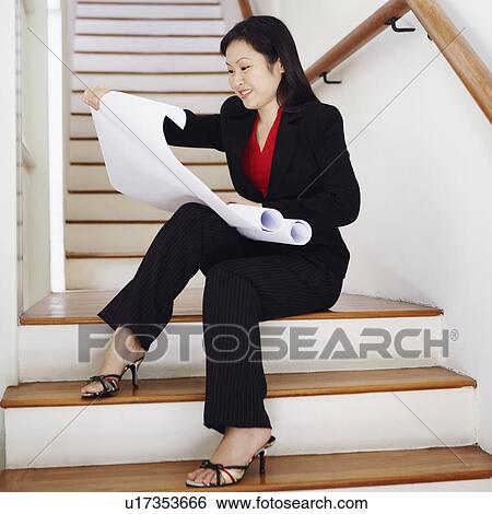 Businesswoman looking at charts and smiling View Large Photo Image Stock Photograph - Businesswoman looking at charts and smiling. Fotosearch