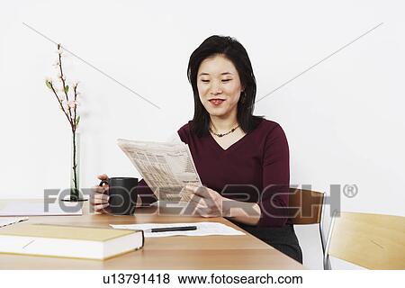 Businesswoman reading a newspaper View Large Photo Image Stock Photo - Businesswoman reading a newspaper. Fotosearch