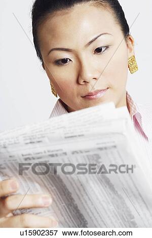 Stock Photo - Close-up of a businesswoman reading a financial newspaper. Fotosearch