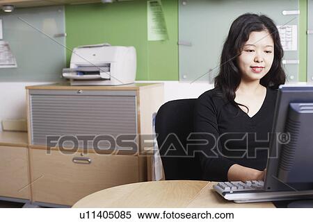 Stock Photography - Close-up of a businesswoman using a computer smiling. Fotosearch