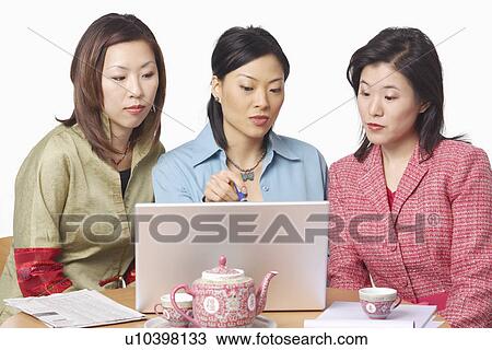 Close-up of three businesswomen in front of a laptop View Large Photo Image Stock Image - Close-up of three businesswomen in front of a laptop. Fotosearch