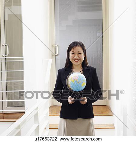 Portrait of a businesswoman holding a globe and smiling View Large Photo Image Stock Image - Portrait of a businesswoman holding a globe and smiling. Fotosearch
