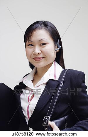 Portrait of a businesswoman holding a handbag and smiling View Large Photo Image Stock Image - Portrait of a businesswoman holding a handbag and smiling. Fotosearch