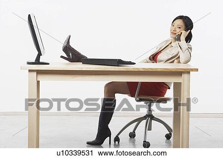 Stock Image - Portrait of a businesswoman talking on a cordless telephone. Fotosearch