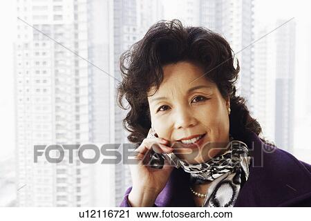 Portrait of a businesswoman talking on a mobile phone smiling View Large Photo Image Stock Image - Portrait of a businesswoman talking on a mobile phone smiling. Fotosearch