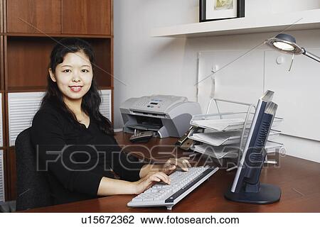 Stock Image - Portrait of a businesswoman using a computer. Fotosearch