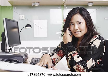 Stock Image - Portrait of a businesswoman using a mobile phone. Fotosearch