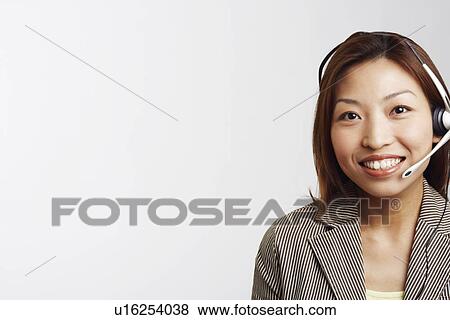 Stock Photo - Portrait of a businesswoman wearing a headset and smiling. Fotosearch