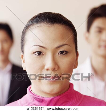 Portrait of a businesswoman with two businessmen in the background View Large Photo Image Picture - Portrait of a businesswoman with two businessmen in the background. Fotosearch