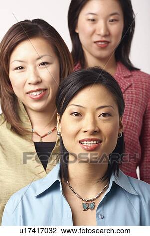 Stock Image - Portrait of three businesswomen smiling. Fotosearch