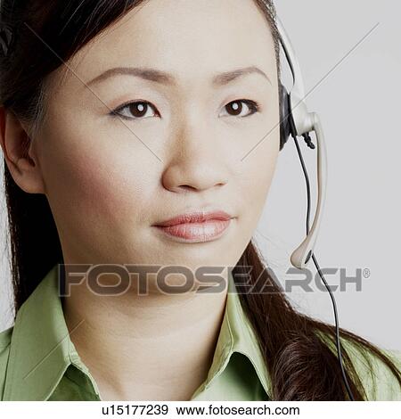 Stock Photo - Close-up of a female customer service representative looking away and thinking. Fotosearch