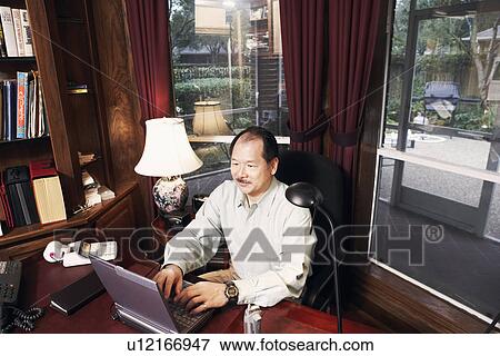 High angle view of a senior man using a laptop View Large Photo Image Stock Photo - High angle view of a senior man using a laptop. Fotosearch
