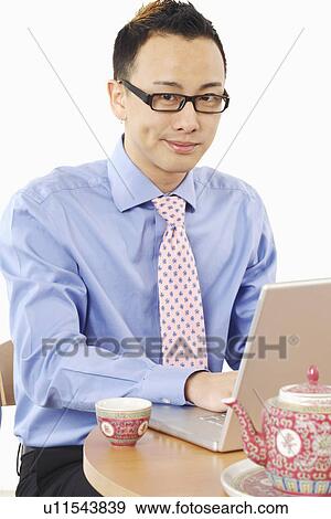 Portrait of a businessman using a laptop View Large Photo Image Stock Photo - Portrait of a businessman using a laptop. Fotosearch